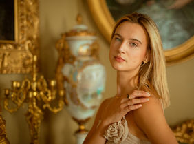 High-fashion commercial jewelry campaign featuring model Leire Telleira. Close-up luxury portrait with a warm, golden aesthetic showcasing fine gold jewelry.