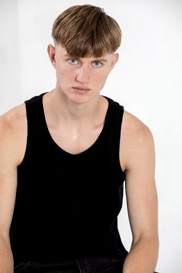 Ian Brighouse male model polaroids in studio, wearing a black tank top and fitted black trousers. London new face digitals from Salitre Models.