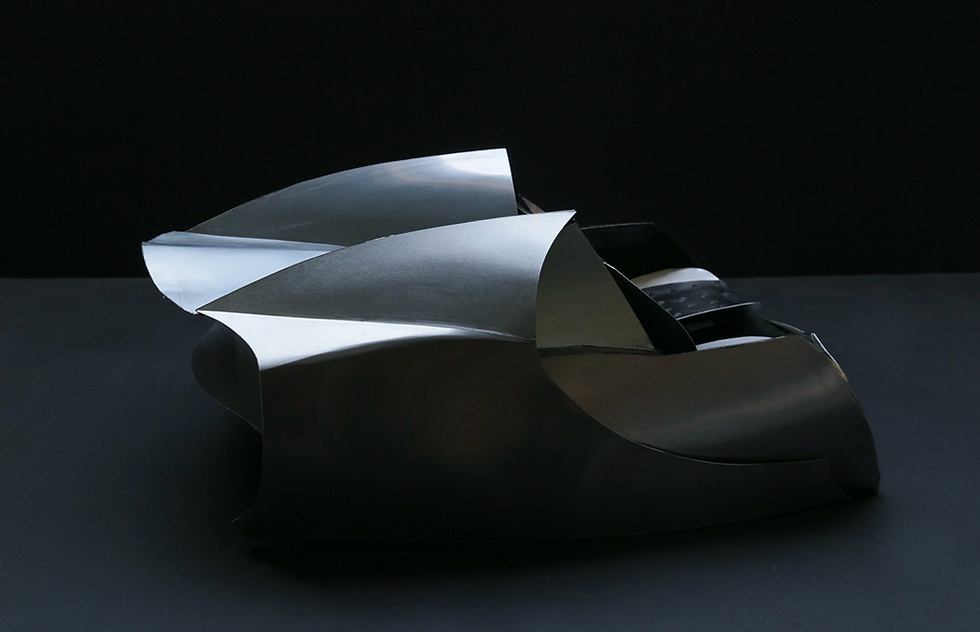 Rear profile of the Scuderia sculptural chair highlighting the sharp aerodynamic tail and hand-finished metallic textures.