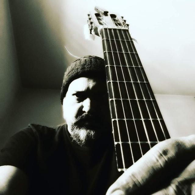 Nando Herrera segurando um violão em primeiro plano