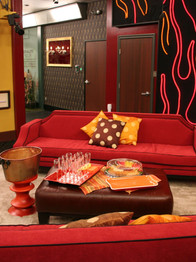 Framed objects for "Big Brother All Stars" on back wall of living room