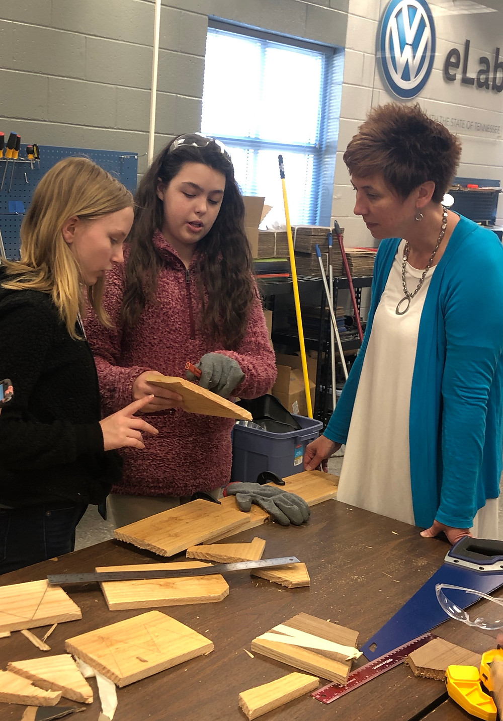 Seventh grade students review their project's progress with Smith.
