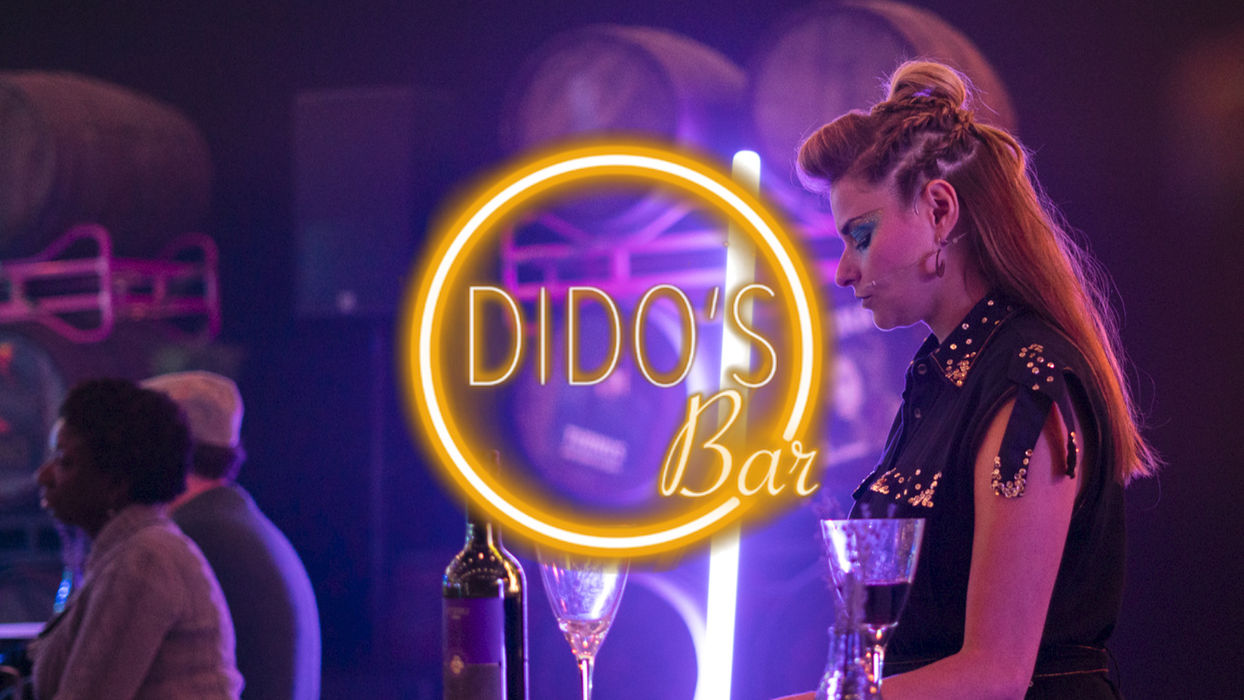 Woman sings and dances at Dido's bar, warm environment.