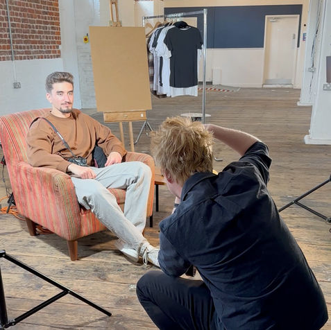 Man takes a photo of another man on a chair