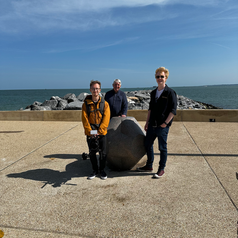 Three people by a marker at The Portsmouth Marker Southsea