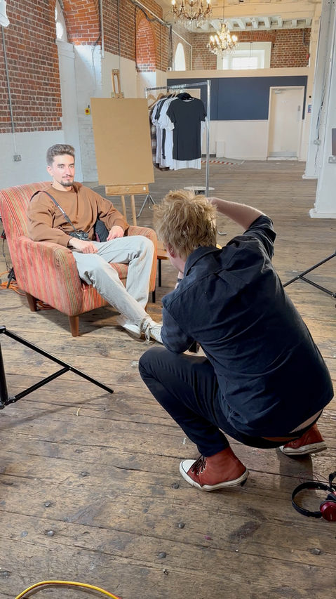 man takes photo of man in chair