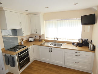 Bright kitchen with white cabinets and wooden countertops