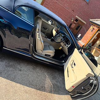 Luxurious black car with a sleek design, parked on a driveway