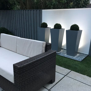 Modern patio with a wicker couch featuring white cushions