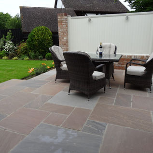 A cosy patio with four cushioned wicker chairs around a table