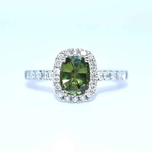 Elegant ring featuring a large green gemstone set in a diamond halo