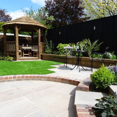 A sunny garden with a wooden gazebo