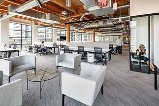 open office space with wooden beams, exposed ductwork, and large windows