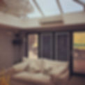 Spacious room with sloped glass roof, featuring a large crystal chandelier