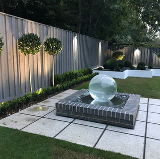 Modern garden with a central glass sphere fountain