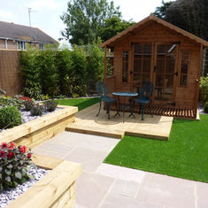 cozy backyard with a wooden shed, patio, artificial grass