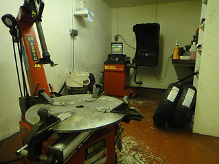 A workshop showing a red tyre changing machine and a wheel balancer