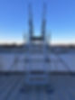 Industrial safety staircase on a metal rooftop under a clear blue sky