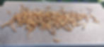 A handful of dried Mealworms shown on a composite board