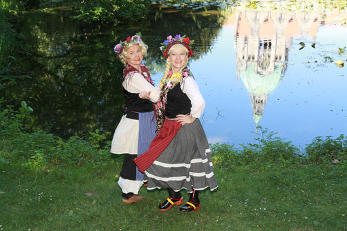 2 Frauen tanzen draußen. Im Hintergrund Hannover Rathaus