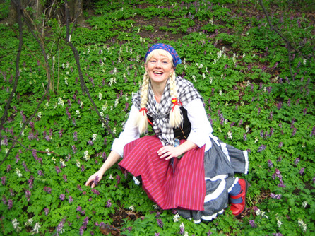 Eins Frau sitzt im grünen. Draußen im Frühling.