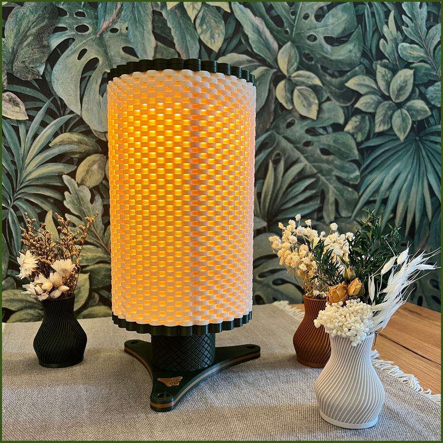 AmbiGlow Lampe auf einer Tichfläche, eingeschaltetes warmes LED-Licht, dekoriert mit VaroVasen und Trockenblumen.