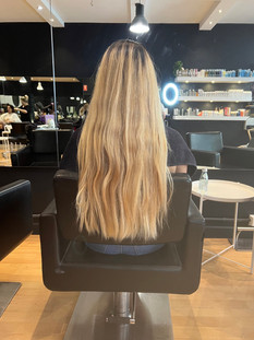 Waist-length yellow/orange hair transformed to a clean natural ash blonde with soft medium layers, rounded shape, and face-framing features by Sunny Sun Hair in Melbourne.