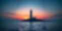 can you create me a calming image of a lighthouse on land and calm sea and a sunrise in th
