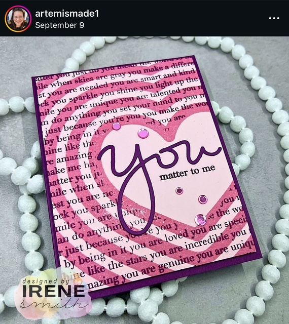 Pink card with a concentric heart design, featuring "You matter to me" text. Surrounded by white beads on a gray surface. Designed by Irene Smith.
