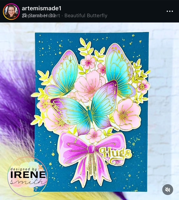 Blue and pink card with vibrant butterflies and flowers, embossed in gold, a large pink bow, "Hugs" text, and artist attribution "designed by Irene Smith."