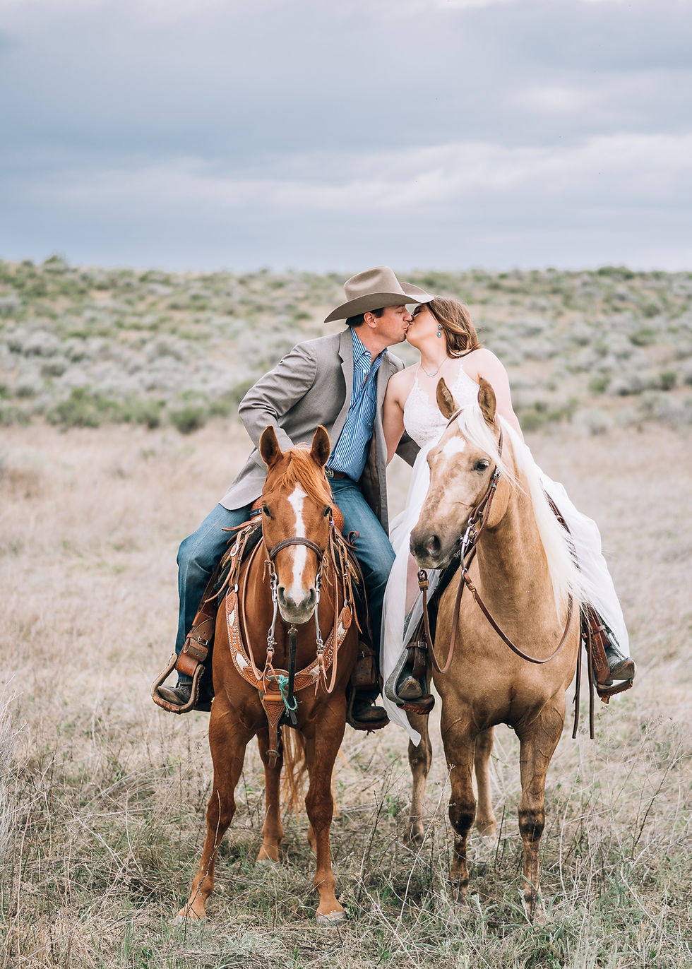 bride and groom kissing on horseback in the desert of Washington