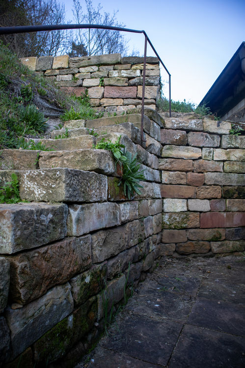 Ausbesserung und Instandsetzung einer Sandsteinmauer mit Treppe
