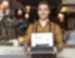 handsome-young-waiter-holding-laptop-with-airbnb-w-2022-12-16-15-43-06-utc(1)(1)-1920w.web