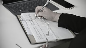 A person writing on a notebook with a la