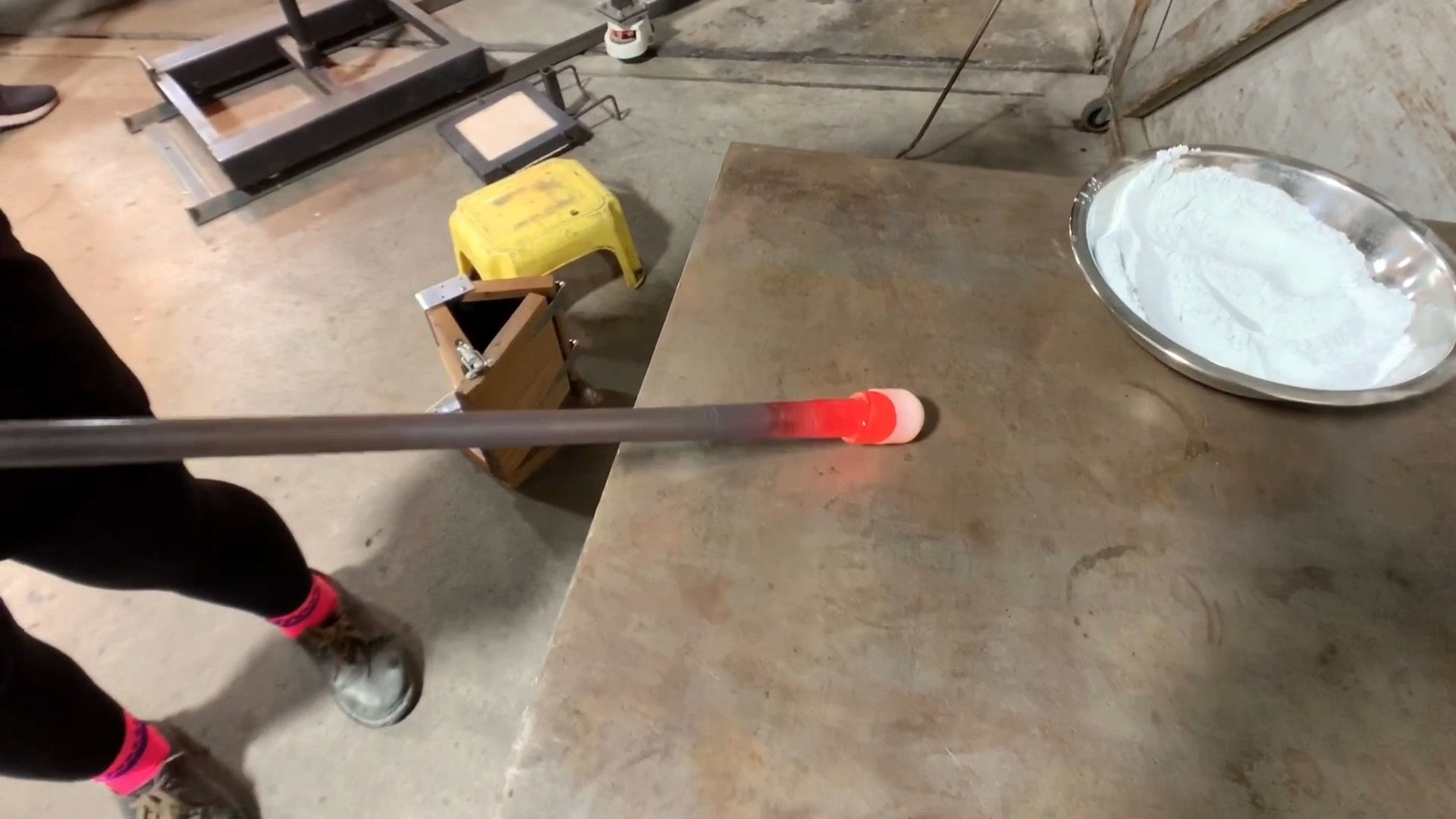 The color drop that was cut onto the bubble is then shaped on the metal marver by rolling it back and forth.