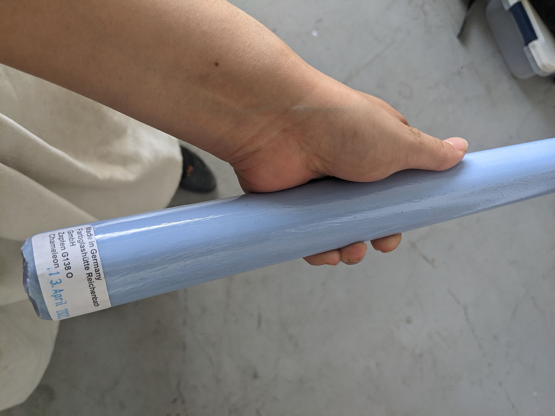 I am holding a solid glass rod of periwinkle blue. The tag on the color bar indicates that it is called "chameleon", Gaffer 138.