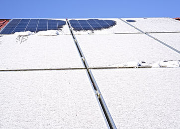 Rooftop solar panels partially covered with snow