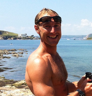 A photo of Ivan smiling infront on the sea
