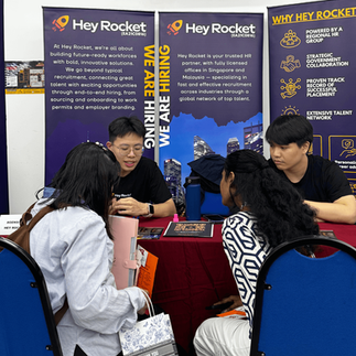  Hey Rocket team member smiling while presenting job opportunities to students, with banners highlighting the company’s services.