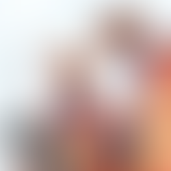 Two construction workers in orange vests and helmets review a tablet. They stand in front of a tall building, focused and engaged.