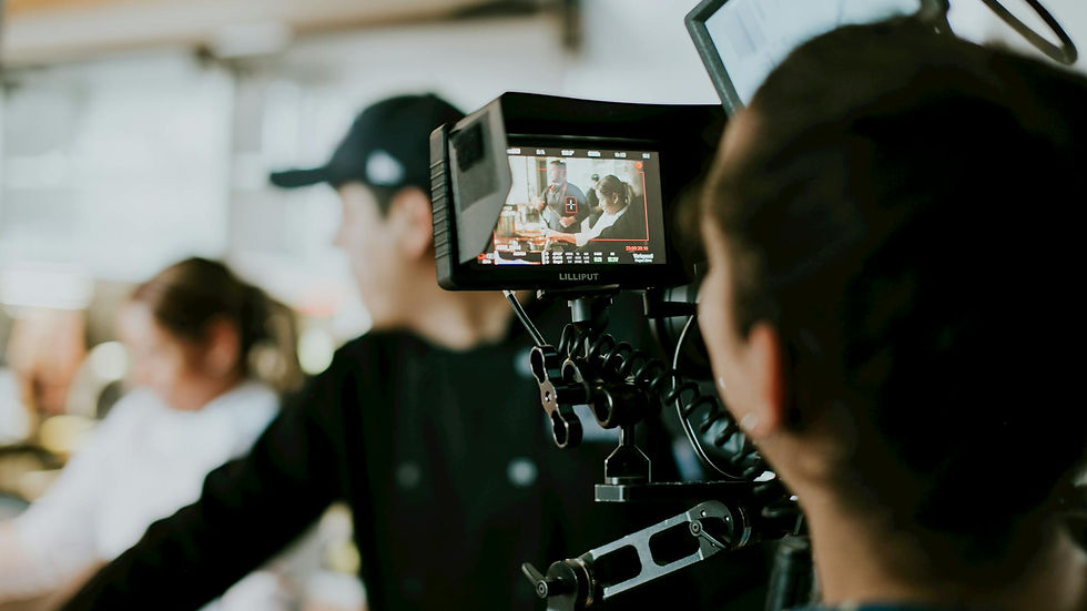 Produção audiovisual: equipe filmando evento corporativo, monitor exibe cena.