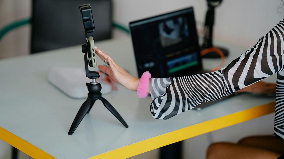 Mulher edita vídeo para Reels no Instagram com notebook e smartphone em tripé. Dicas de vídeo.