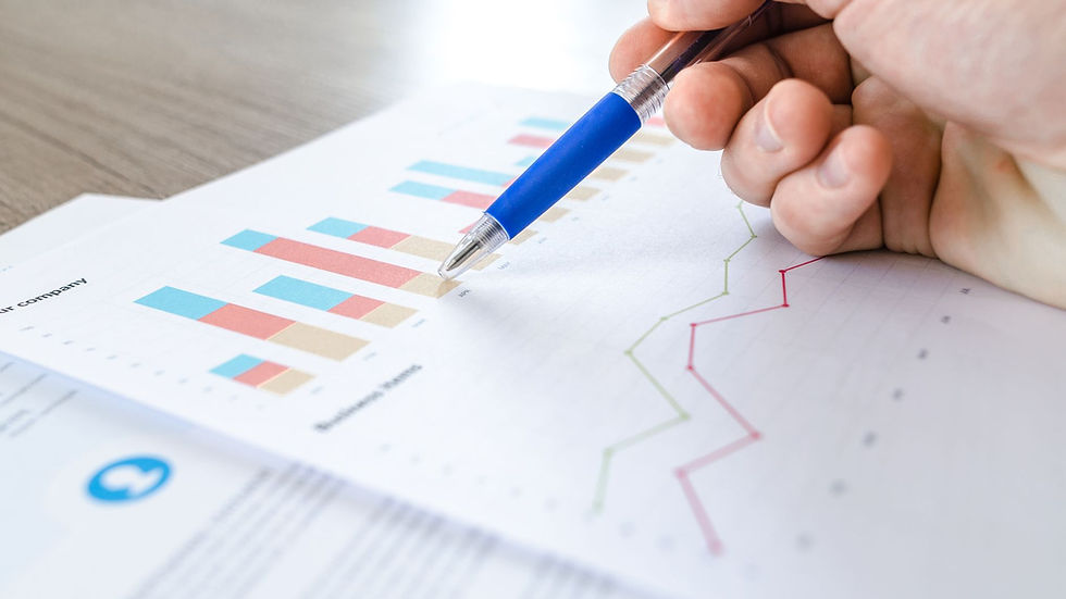 Mão com caneta analisando gráficos de ROI em publicidade de vídeo marketing digital.