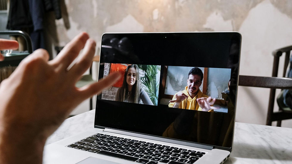 Pessoas em reunião virtual por laptop, demonstrando como escolher plataforma de transmissão ao vivo para eventos.
