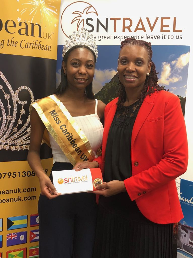Elizabeth receives her travel tickets to Grenada from Donna Joseph, Sales & Marketing Director