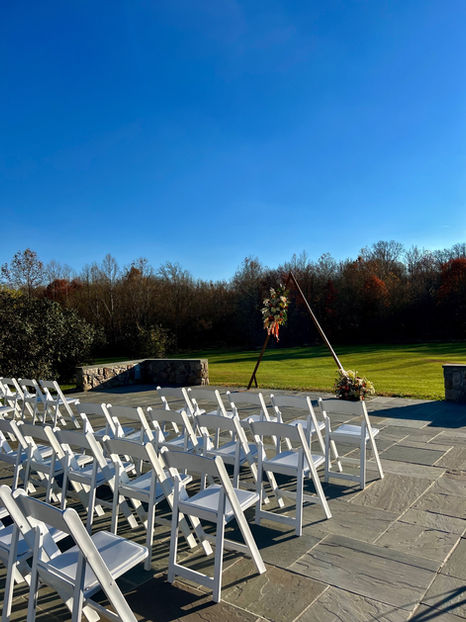 Sunset Wedding ceremony with a triangular wedding arch and fall flowers