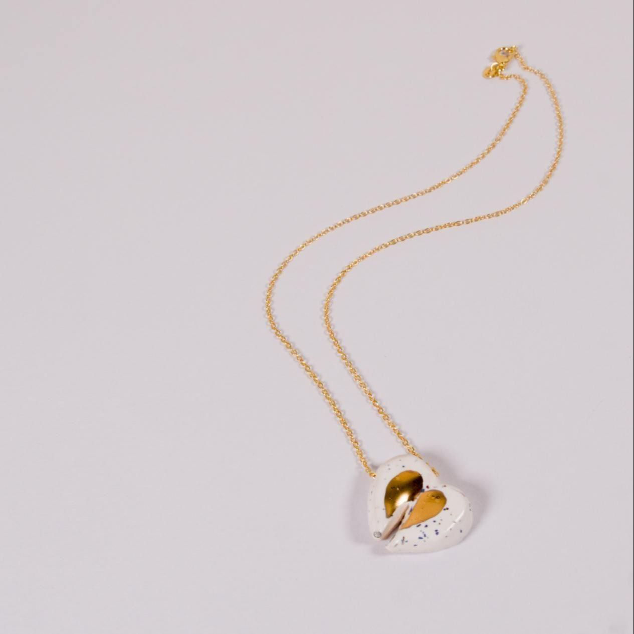 Goldene Halskette mit Herzanhänger auf weißem Hintergrund Schmuckdesign