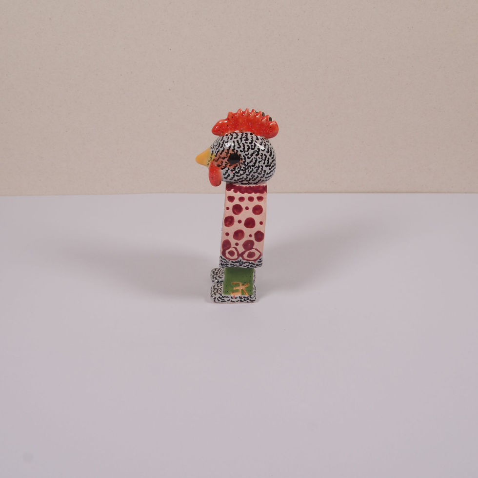 Miniaturbild: Ein bunter Hahn Figurine mit rotem Kamm und gepunktetem Oberteil auf weiß.