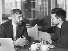 A professional man getting expert resume feedback from a recruiter to fix resume red flags for senior leaders that are holding back his job search.