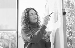 Recruiter sharing job market trends and hiring insights as she presents with a whiteboard.